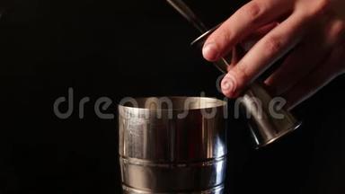 特写镜头，一个酒保把液体倒进一个鸡尾酒酒壶。制作酒精鸡尾酒饮料的过程。